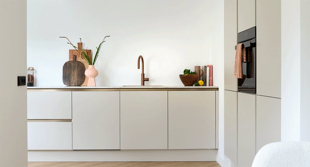 japandi-beige-hoekkeuken-met-bronzen-greeplijsten-satink-keukens japandi-beige-hoekkeuken-met-bronzen-greeplijsten-satink-keukens